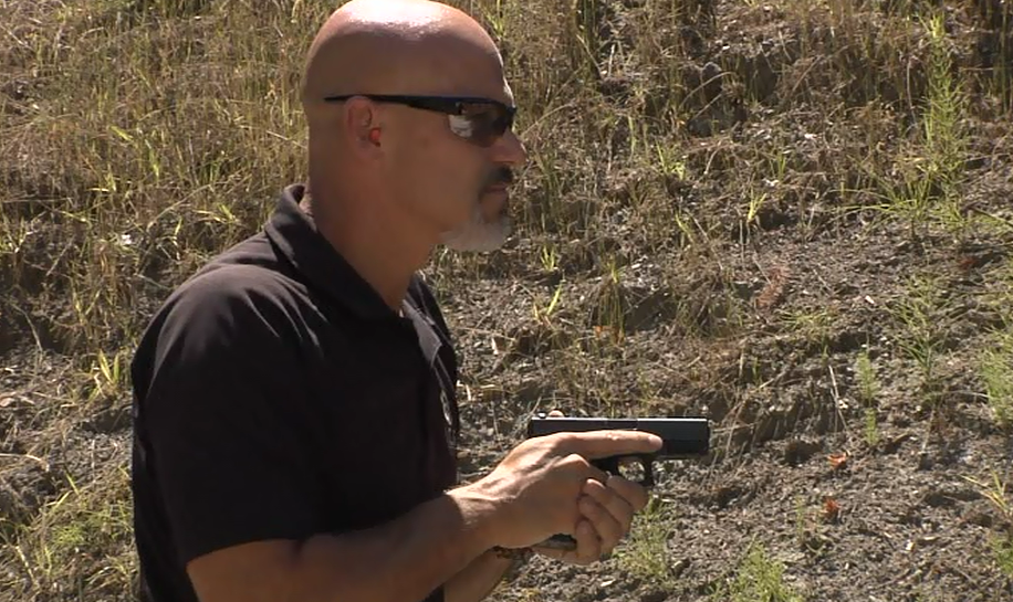 Man holding a gun in a close grip