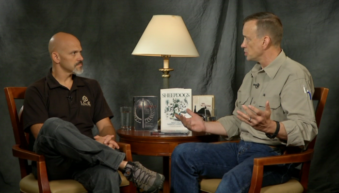 Two men sitting in chairs talking