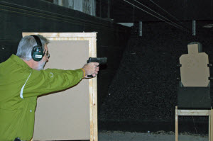 Man with ear protection shooting a gun