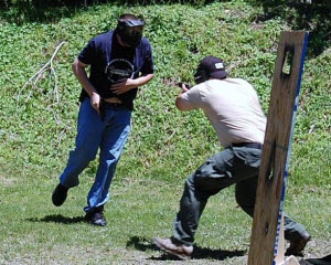 Shooter in tan shirt pushes off with rear foot, raised heel, tight core and bent knees.