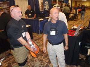 Clyde Caceras demonstrates new product for controlling combative subjects at 1 Inch to 100 Yards Warrior Conference Expo.