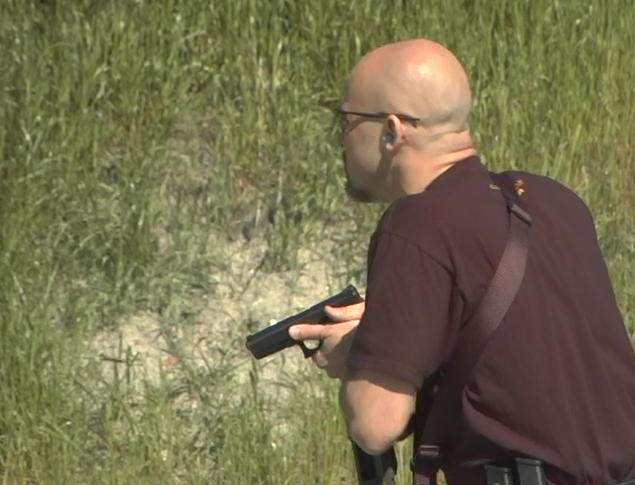 Man outside holding a pistol