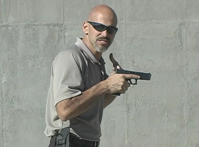 Man from the side holding a gun