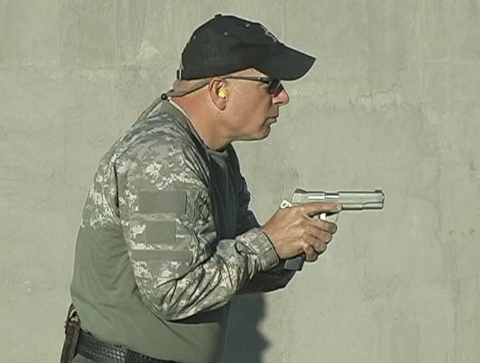 Man aiming a gun in a close grip