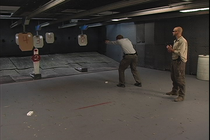 Man aiming at indoor targets with numbers on it