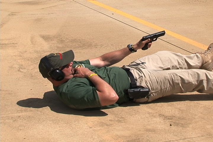 Man laying on the ground aiming a gun