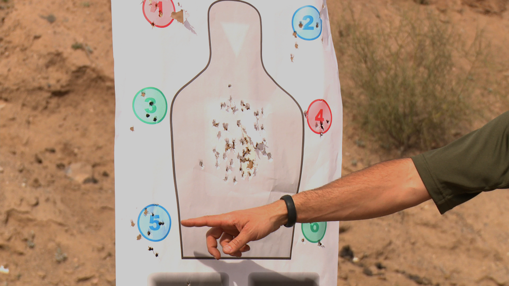 Person pointing to a complete gun target sheet