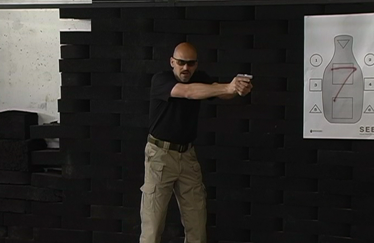 Man aiming a gun near an indoor target