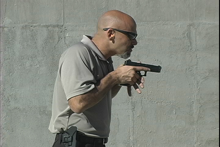 Man holding a handgun close to his chest