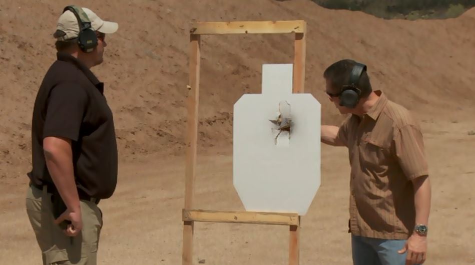 Two men looking at a shot through an outdoor target