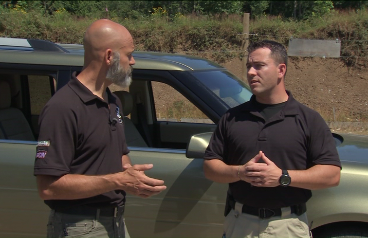 Two men talking beside a vehicle