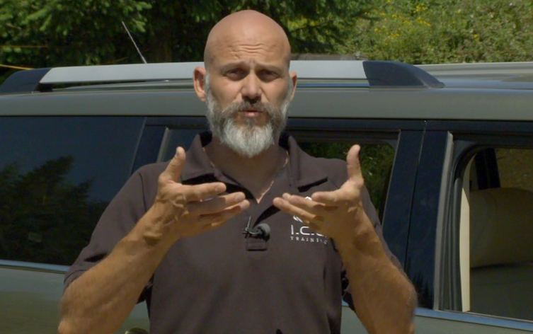 Man in a polo talking near a vehicle