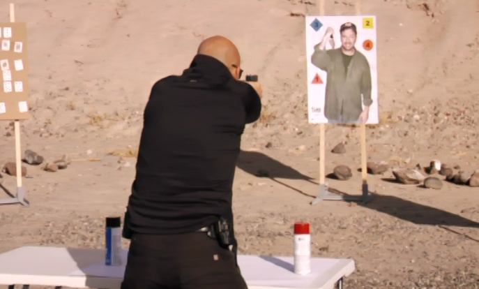 Man outside aiming at an image of a man as a target