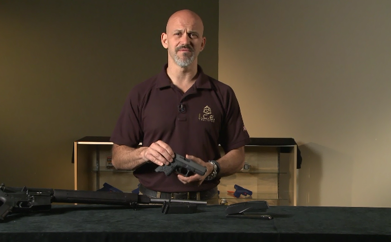 Man with different guns on a table