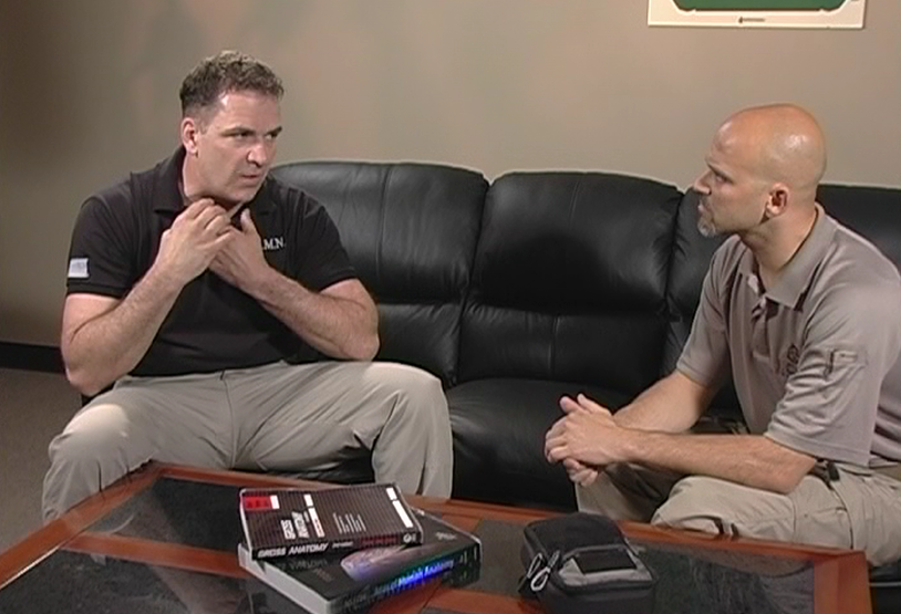 Two men talking on a leather couch