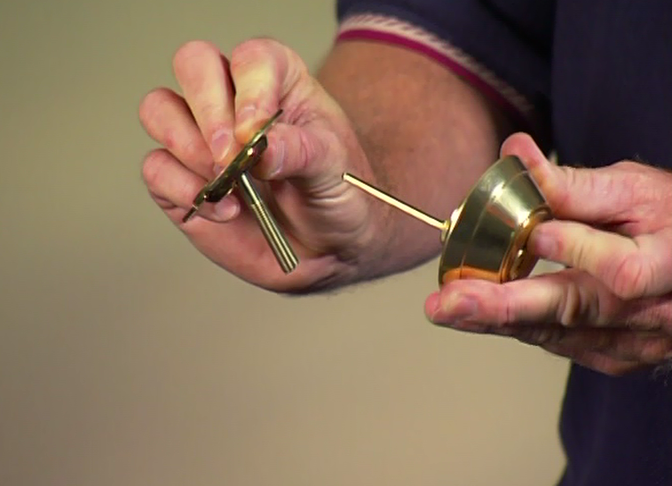 Person holding pieces to a door lock