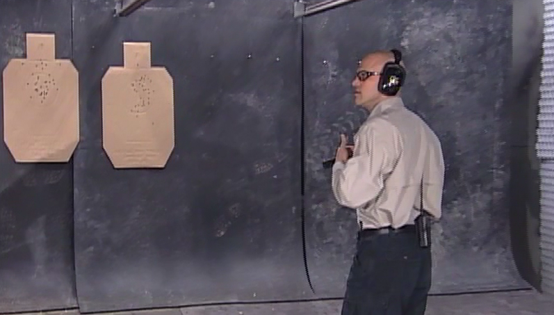 Man wearing ear and eye protection at an indoor shooting range