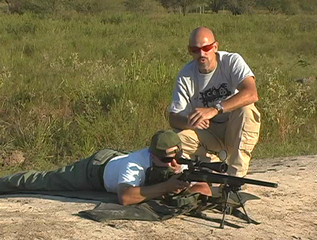 Man laying down aiming a gun