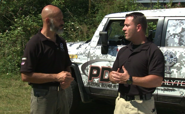 Two men talking in front of a PDN vehicle