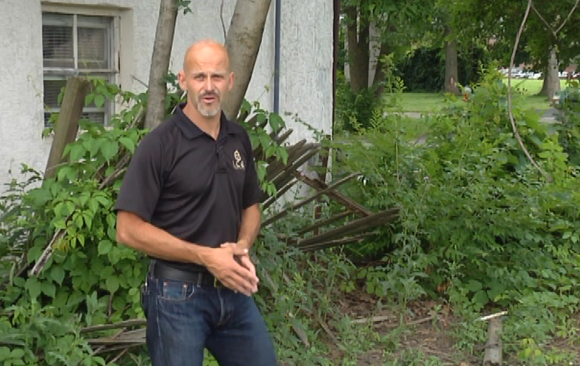 Man talking outside by the side of a house