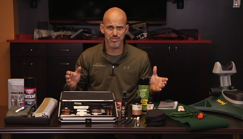 Man with table of materials for firearm maintenance