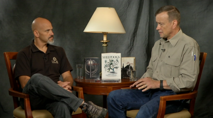 Two men sitting in chairs talking