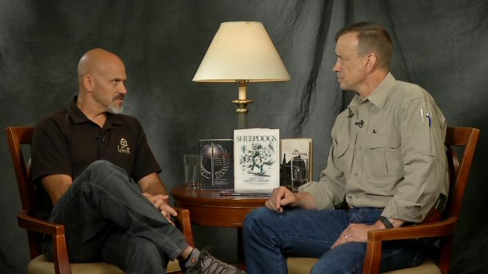 Two men sitting in chairs talking