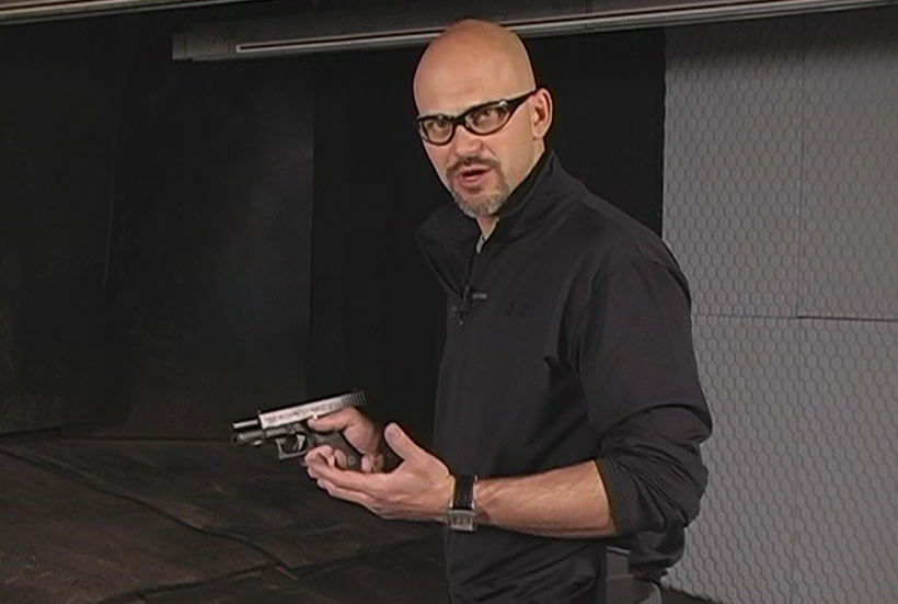 Man wearing protective eye gear holding a gun