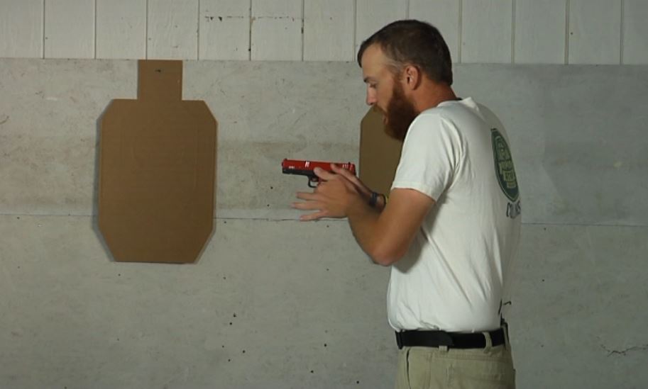 Man with a gun in a close grip position