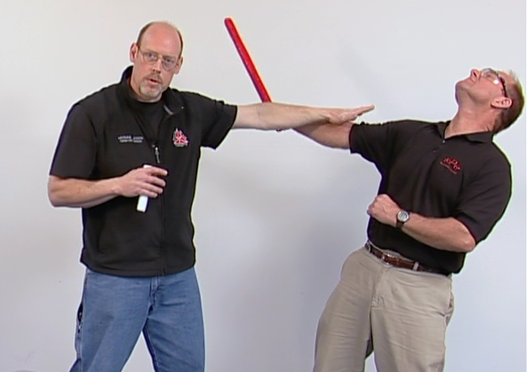 Man showing practical stick defense on another man