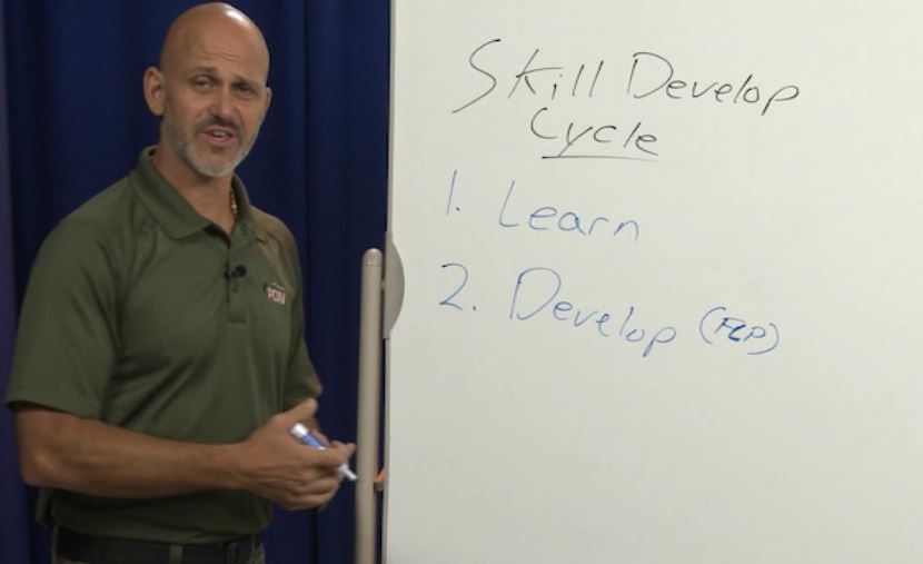 Man writing on a whiteboard about skill develop cycle