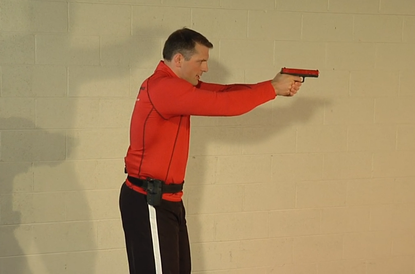 Man in red aiming a red training gun