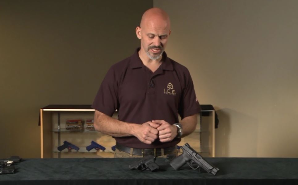 Man looking at a gun on a table