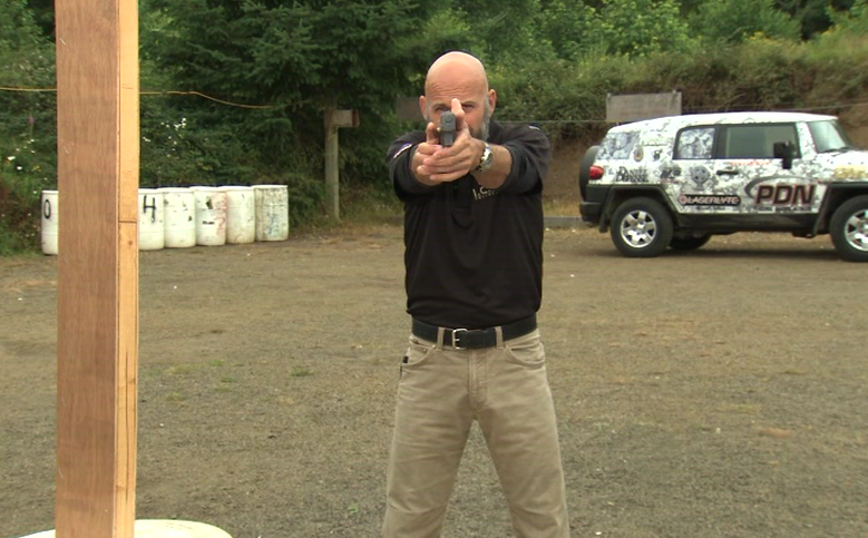 Front view of a man pointing a gun