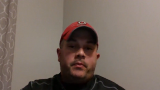 Screen shot of a video of a man in a red hat