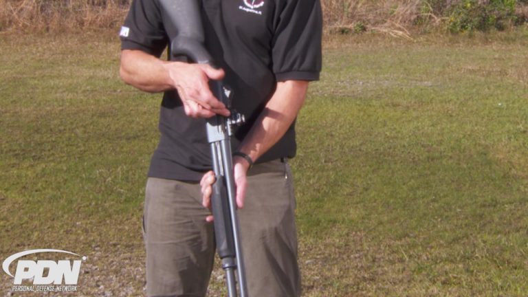Man outside holding a 20-gauge shotgun