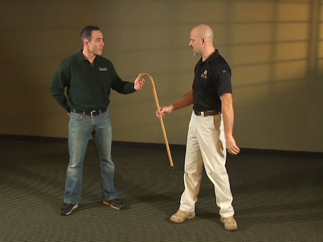 Two men doing defense with a cane