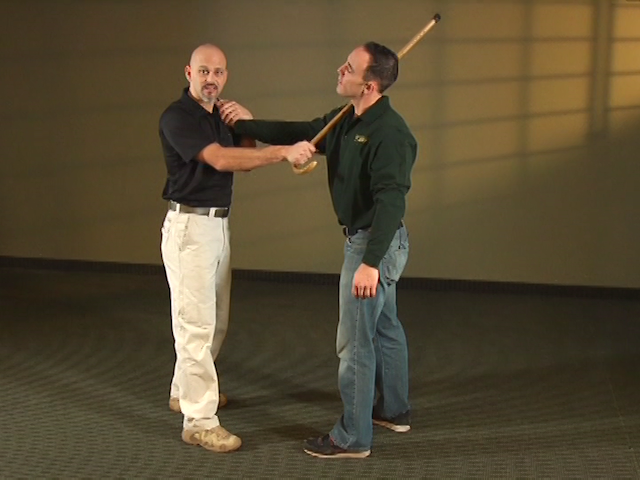 Two men practicing defense with a cane