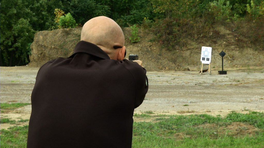 Man outside aiming at a target