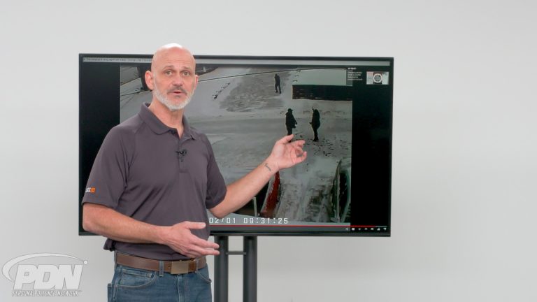 Man showing two people fighting in the snow on a screen