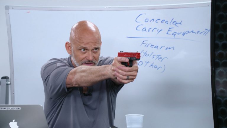 Man holding a red hand gun