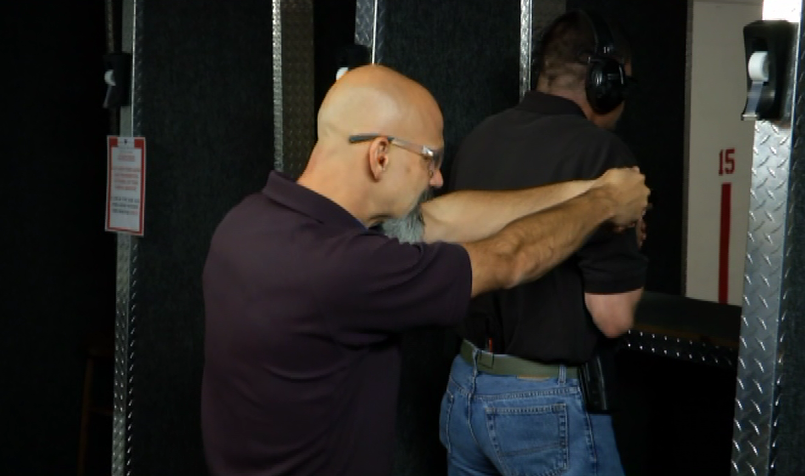 Two men at an indoor shooting range