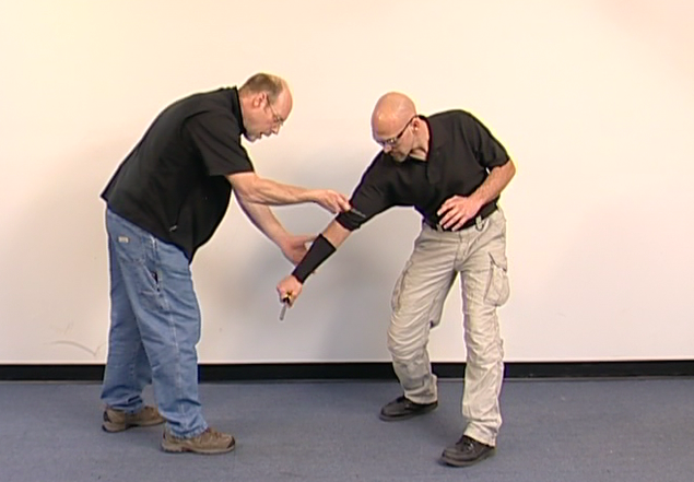 Two men doing defensive knife training