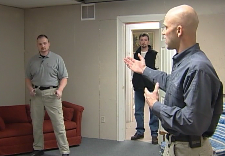 Man holding a knife in an attack simulation in a room