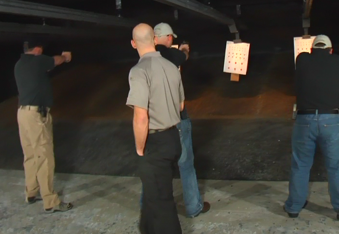 Men practicing shooting at an indoor range