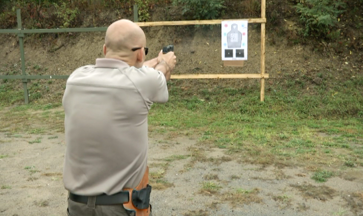 Man aiming at a target on a board