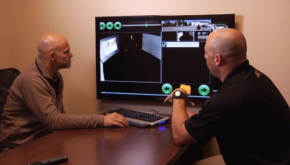 Two men looking at security footage on a screen