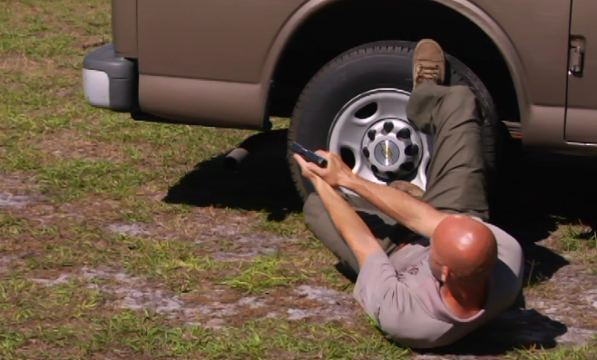 Man aiming a gun from the ground