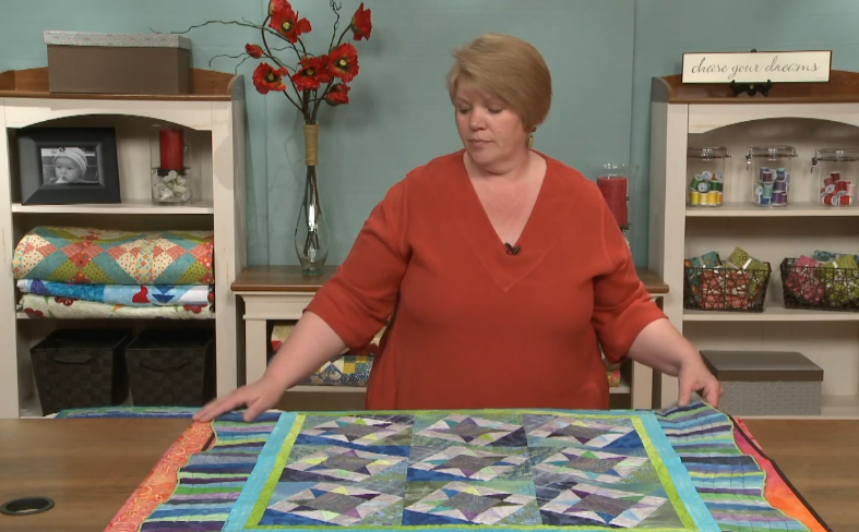 Woman with a large quilt on a table
