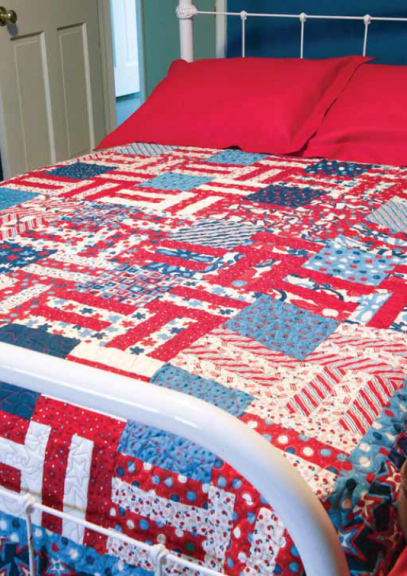 Red, white and blue quilt on a bed